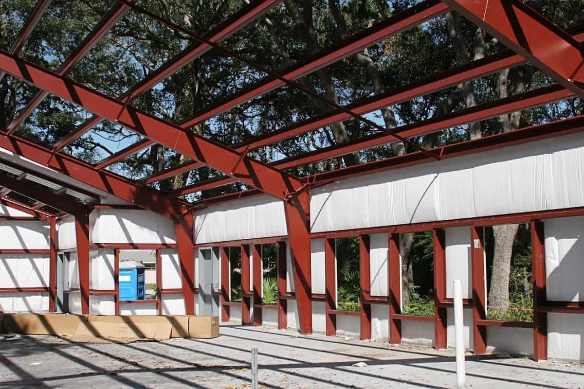 Vinyl-faced fiberglass insulation installed in a metal building under construction